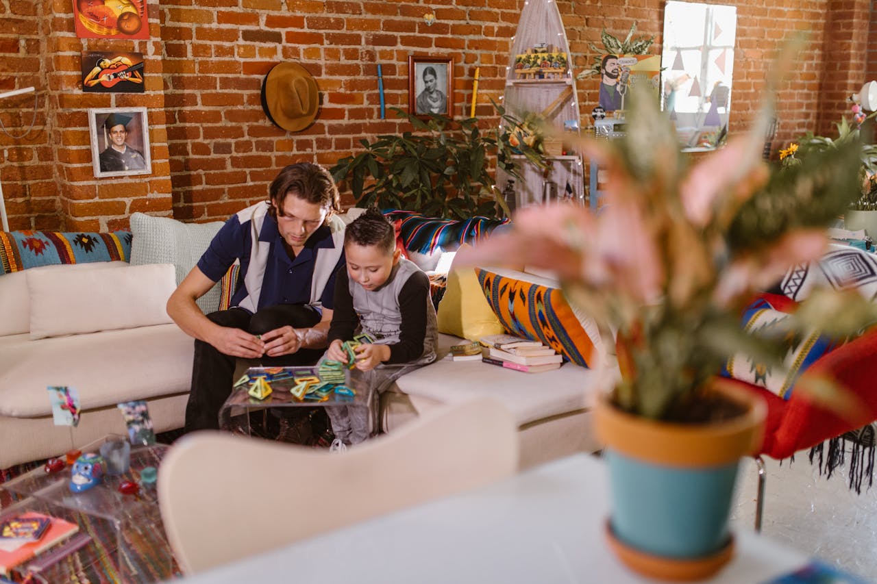 services-01 A father and son building with magnetic blocks in a cozy living room setting.